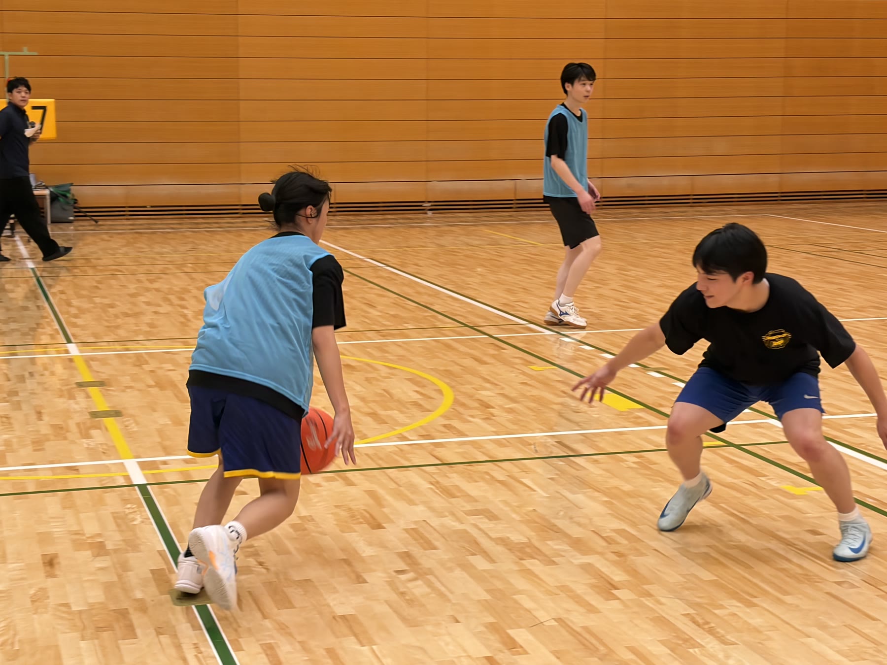 球技の試合でボールを持ってプレーする学生