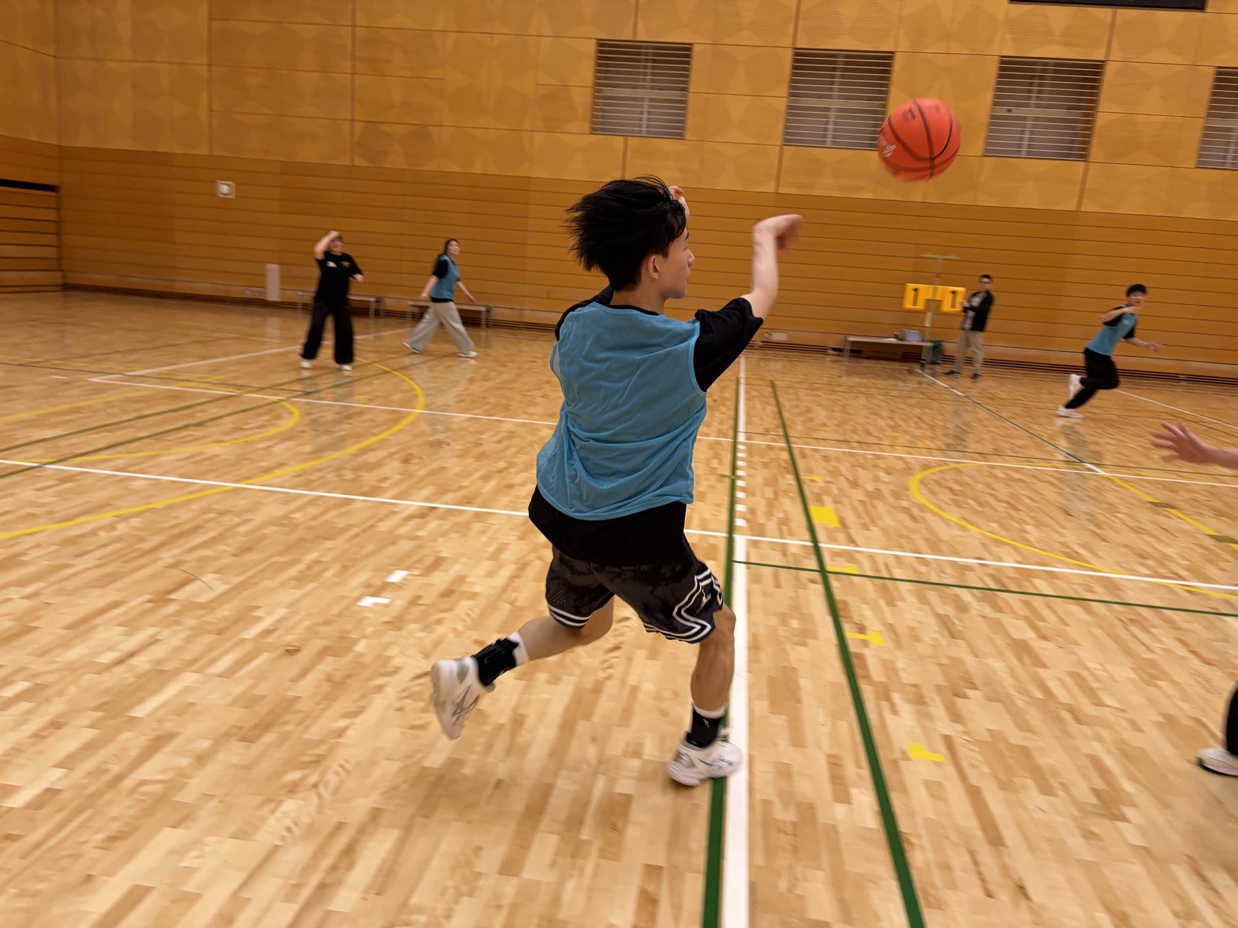 大きく踏み込み味方へボールを送る学生